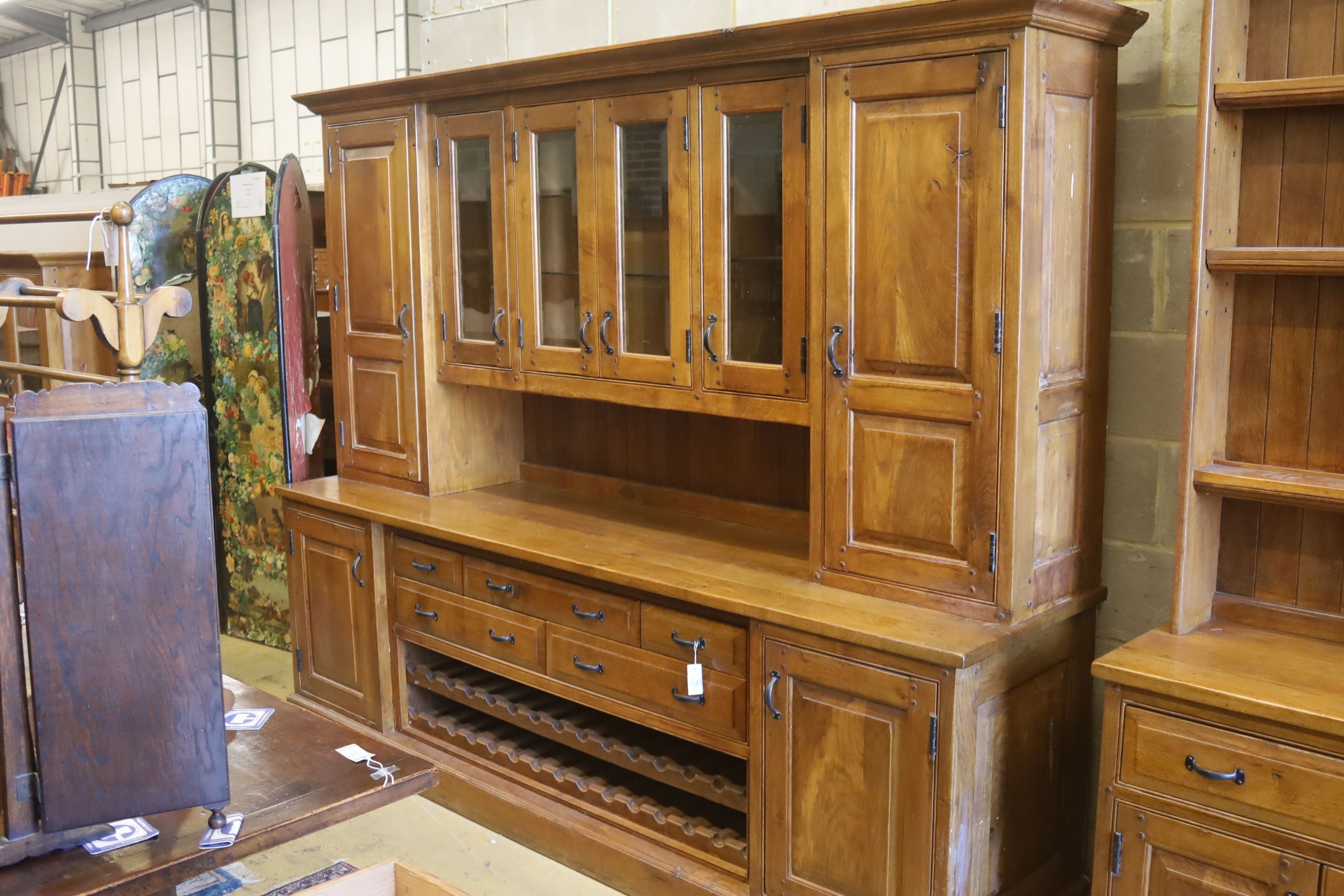 A large reproduction oak dresser with wine bottle storage, length 244cm, depth 60cm, height 201cm